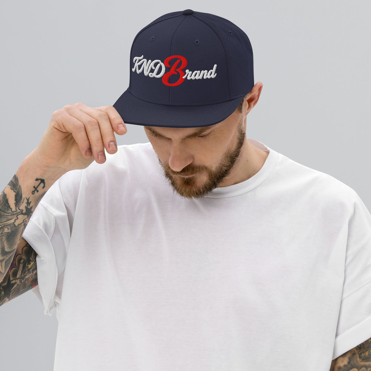 KND Script Snapback in navy — white KND Brand script with a red B embroidered front, front view