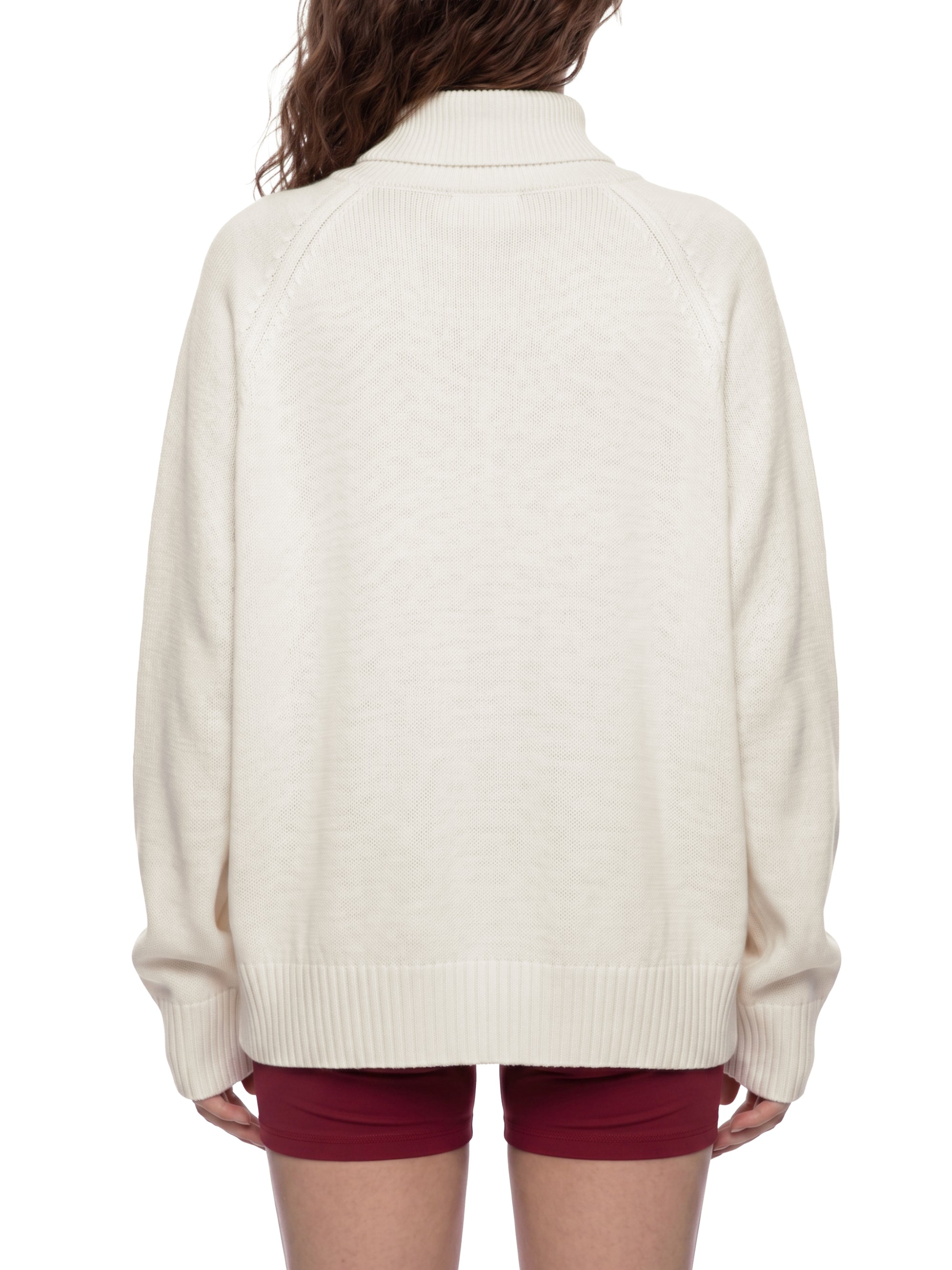 Female model wearing the KND Brand quarter-zip sweater with the collar zipped