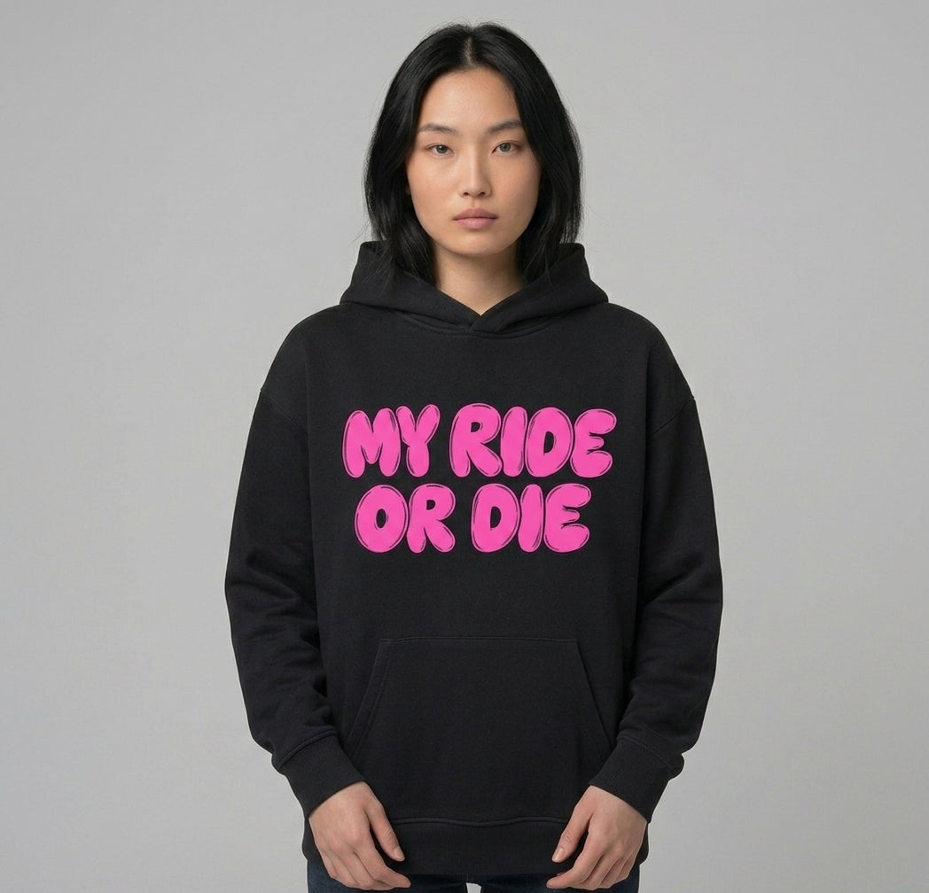 My Ride Or Die hoodie worn by a model — black oversized pullover with MY RIDE OR DIE across the chest in pink bubble lettering, hood down