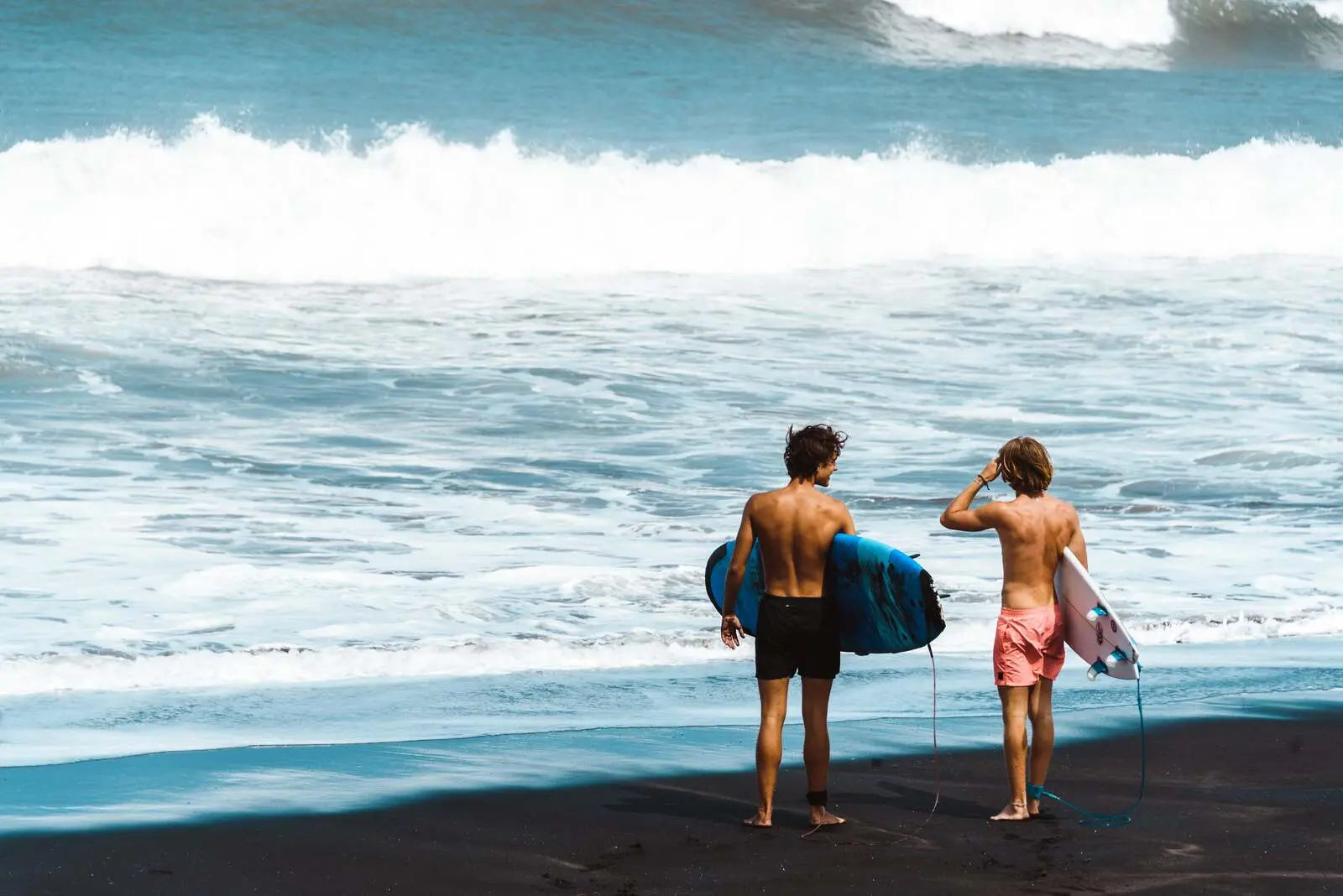 Surfers standing on the shore, reflecting KND Brand's California coastal style